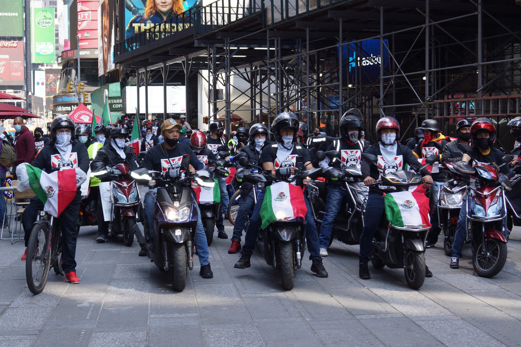 Deliveristas, representing their home country of Mexico, prepare to make their way downtown